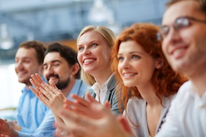 Photo of happy business partners applauding at conference